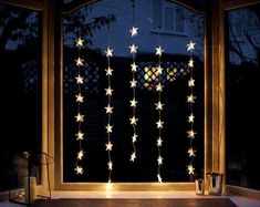 a lighted window with stars hanging from it