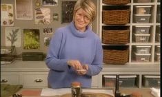 a woman standing in front of a table holding a spoon