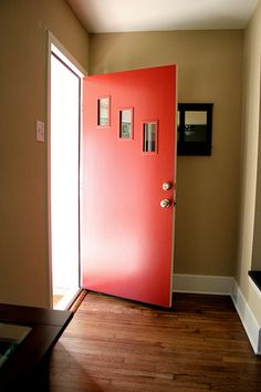 a red door is open in an empty room