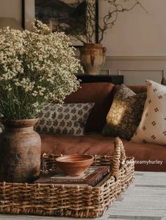 a living room filled with lots of furniture and flowers on top of a coffee table