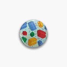 a button with legos on it sitting on top of a white surface next to a wall