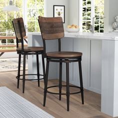 two wooden barstools sit in front of a counter