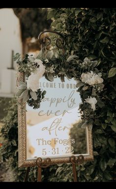 a sign with flowers and greenery on it that says, welcome to our happily ever after the fogs 5 31