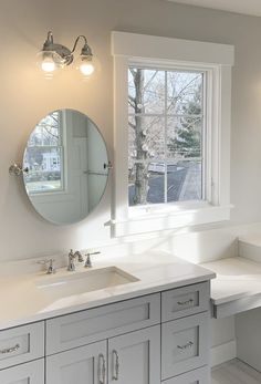 a bathroom with two sinks and a large mirror in it's center window area