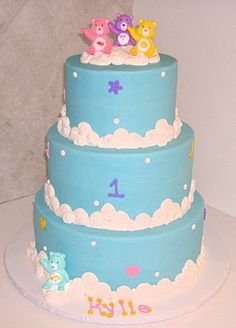 there is a three tier cake with teddy bears on the top, and clouds in the bottom