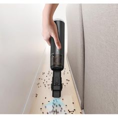 a person is vacuuming the floor with a small machine on it's side