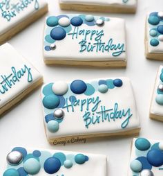 decorated cookies with blue and white icing are arranged on a table for a birthday