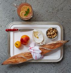 a tray with bread, fruit and nuts on it