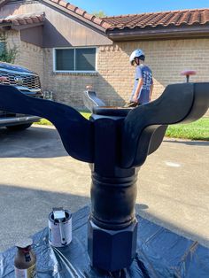 a man standing on top of a roof next to a blue pipe with a wrench in it's mouth