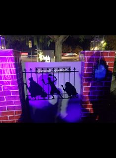 the silhouettes of people are projected on a gate