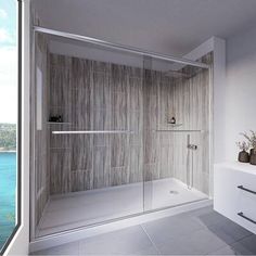 a walk in shower sitting next to a bathroom sink and window overlooking the ocean on a sunny day