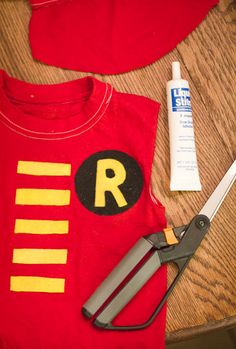 scissors, glue and t - shirt sitting on top of a table