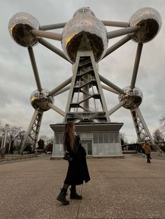 a woman standing in front of a large structure