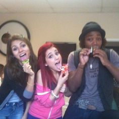 three people are posing for the camera with toothbrushes in their mouth and one person is eating something