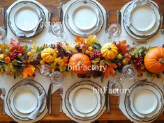 the table is set with silverware and pumpkins