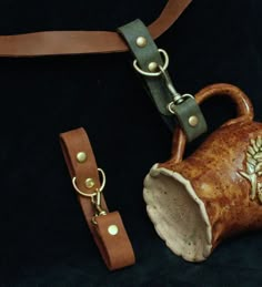 a brown leather strap with a teapot on it and a keychain attached