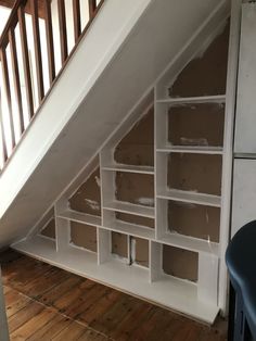 an under the stairs storage unit in a house with wood flooring and white painted walls