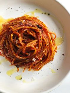 a white plate topped with spaghetti and sauce