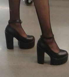 a woman's legs in high heeled black shoes