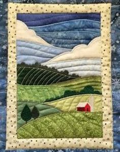 a quilted wall hanging on the side of a blue building with a red barn in it