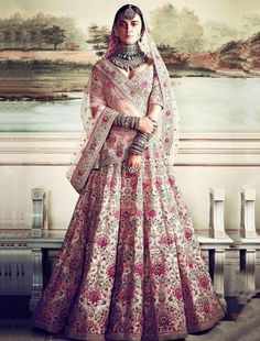 a woman in a bridal gown standing next to a painting