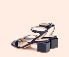 The ANGIE sandal is the result of the style experiments of the AGL workshops, where shoes become sophisticated design pieces. The squared sole and the cube-shaped heel are the stand-out features of this creation with its pared-back lines and elegant lacquered finish. Leather Sandals With 4-inch Heel And Almond Toe, Leather Sole T-strap Slingback Sandals, Blue Block Heel Sandals With 4-inch Heel, Shoe Collection, Sandals, Heels, Leather