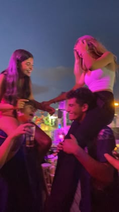 a group of people standing next to each other at a party in front of a city skyline