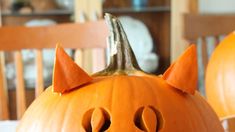 two pumpkins with faces carved into them sitting on a table