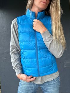 Stay toasty and on trend with the Beacon 2 Vest! This ultra-cozy puff vest has a high-neck design and a storage pouch for all your essentials. Keep warm and snug whether you’re out and about or just lounging around. Feeling fly has never been so easy! Cold Weather Solid Puffer Vest, Winter Functional Solid Vest, Solid Puffer Vest For Cold Weather, Solid Color Puffer Vest For Cold Weather, Functional Solid Winter Vest, Functional Solid Color Winter Vest, Blue Winter Vest For Outdoor Activities, Blue Vest For Outdoor Winter Activities, Functional Blue Vest For Winter