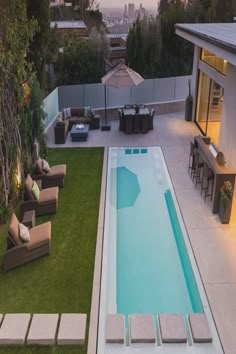 an aerial view of a backyard with a swimming pool and lounge chairs in the foreground