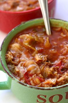 two red and green bowls filled with soup on top of a white table next to each other