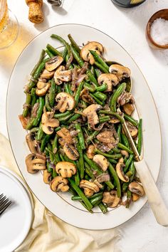 a white plate topped with green beans and mushrooms