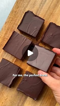 someone is cutting up some chocolate squares on a wooden board with the words for me, the perfect treat