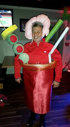 a man in a red costume holding two large green and yellow items