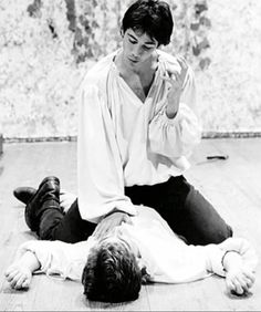 a black and white photo of a man sitting on the floor with his head in his hands