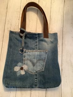 a denim bag with flower appliqued on it