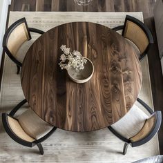 an overhead view of a dining table with chairs and a vase on the table top