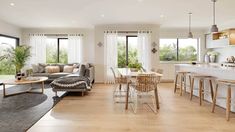 a living room filled with furniture next to a kitchen and an open concept dining area