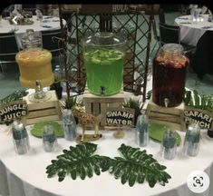 a table topped with different types of drinks on top of a white table cloth covered table