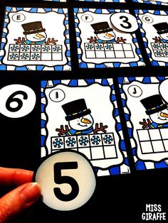 a hand holding a number five game with the numbers in front of it and six on each side