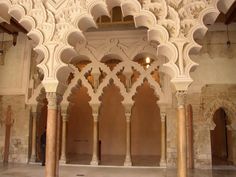 the inside of an ornate building with columns and arches on either side of the room