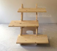 three wooden shelves stacked on top of each other in an empty room with white walls