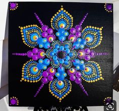 a painting on a black board with blue, purple and yellow designs