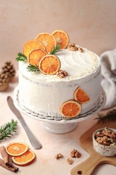 there is a cake with orange slices on top and nuts around the edges, along with other decorations