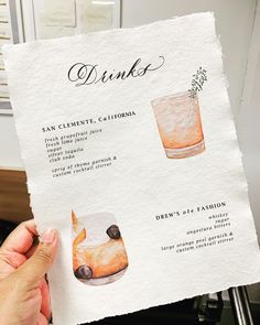 a person holding up a menu for drinks