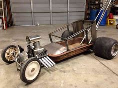 an old style car is being worked on in a garage, with the wheels still attached to it