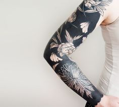 a woman with black and white flowers on her arm