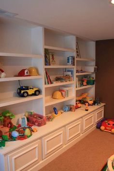 a child's room with toys and bookshelves on the wall, along with stuffed animals