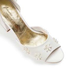 a pair of white shoes with pearls on them