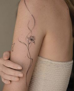 a woman's arm with a flower tattoo on the left side of her arm